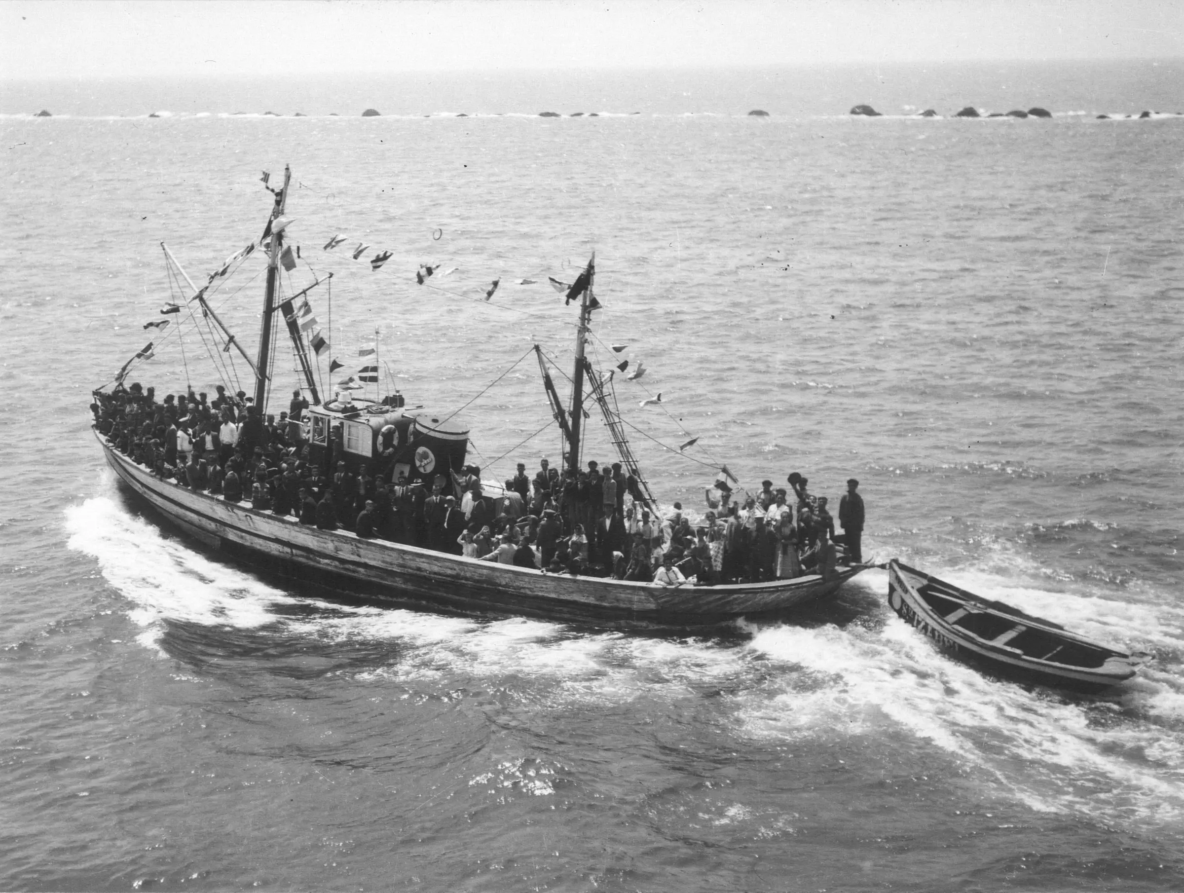 Fotografia histórica de uma traineira cheia de pescadores ao largo de Matosinhos
