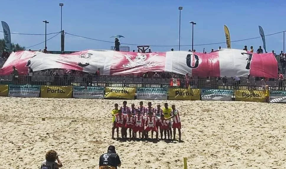 Equipa de futebol de praia do Leixões diante de uma bandeira gigante dos adeptos