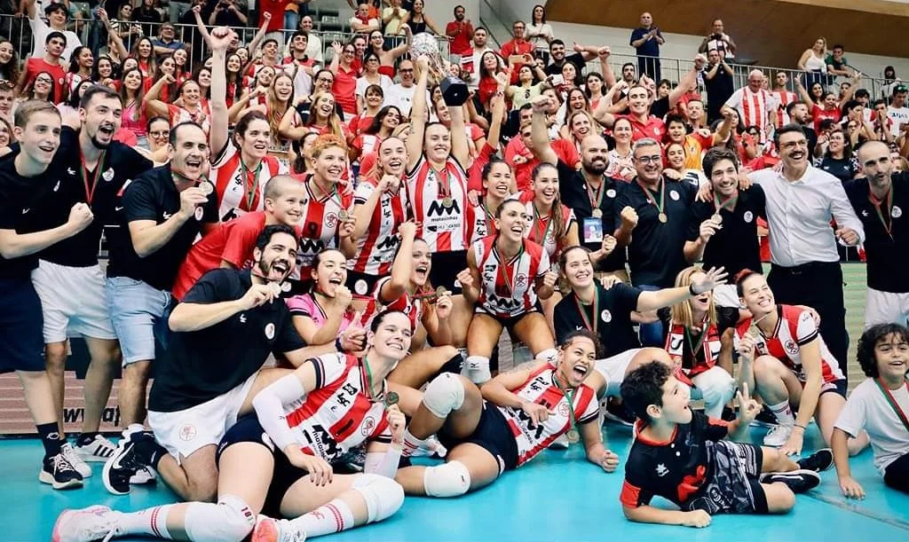 Equipa feminina de voleibol do Leixões a celebrar a conquista de um título com adeptos na bancada